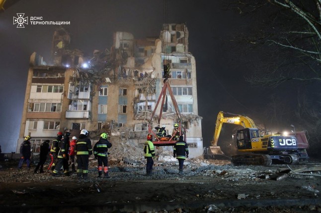Rescuers transport the body of a person found under debris