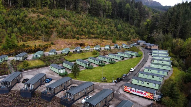 An aerial view of caravans at a Cove UK holiday park, surrounded by forests.