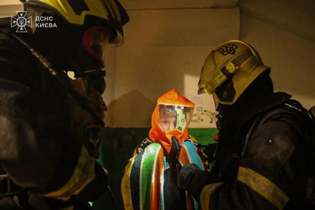 This handout picture taken and released by Ukrainian Emergency Service shows firefighters helping residents evacuate from a damaged residential building following Russian missiles and drones strikes in Kyiv on November 25, 2025, amid Russian invasion in Ukraine. Ukraine's energy ministry said a "massive" attack targeting power facilities was underway early on November 25,2025, as the military reported a barrage of drones and missiles fired at the capital Kyiv. (Photo by Handout / Ukrainian State Emergency Service / AFP via Getty Images)