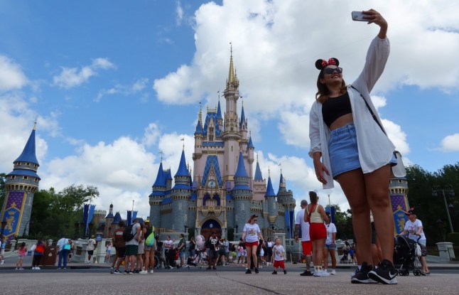 ORLANDO, FL - APRIL 3: A woman takes a selfie before Cinderella's Castle at the Magic Kingdom Park at Walt Disney World on April 3, 2025, in Orlando, Florida. (Photo by Gary Hershorn/Getty Images)