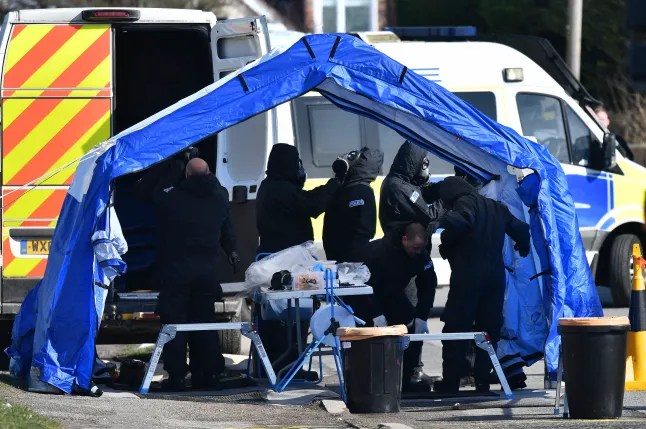 Police in protective coveralls with breathing equipment work on the grounds of a cement plant near Salisbury (Picture: Ben Stansall/AFP)