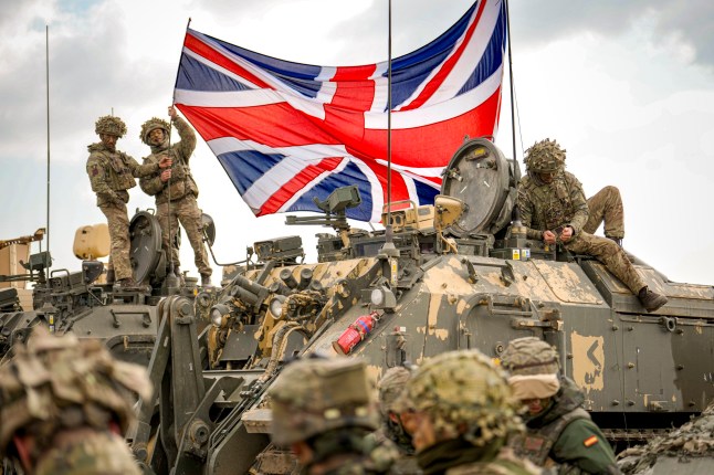 British servicemen unfurl the Union Jack flag before the start of the Steadfast Dart 2025 exercise