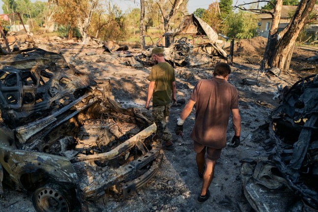SLOVIANSK, UKRAINE - AUGUST 20: Ukrainian soldiers inspect the site of a Russian Shahed drone strike that destroyed vehicles and residential buildings the previous day on August 20, 2025 in Sloviansk, Ukraine. Sloviansk is the city where the war in Donbas began in 2014, marked by its occupation by Russian militias led by Igor Strelkov, also known as Girkin. The town is located in Donetsk Oblast, a Ukrainian region cited in peace-talk discussions involving U.S. President Donald Trump and Russian President Vladimir Putin over a potential frontline freeze and territorial exchanges. (Photo by Pierre Crom/Getty Images)