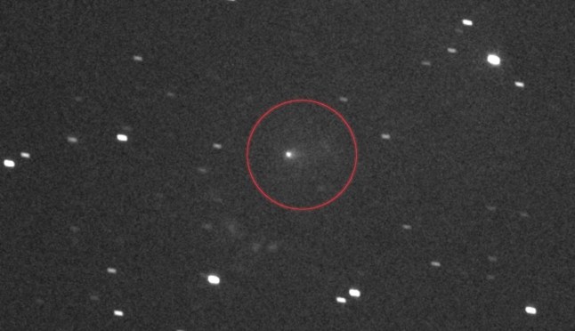 This NASA image obtained on November 19, 2025, shows the interstellar comet 3I/ATLAS, circled in the center, as seen by the L'LORRI black-and-white imager on NASA's Lucy spacecraft. This image was made by stacking a series of images taken on September 16, 2025, as the comet was zooming toward Mars and spacecraft Lucy was 240 million miles away from 3I/ATLAS. The image shows the comet's coma, the fuzzy halo of gas and dust surrounding 3I/ATLAS above, and its tail, a smudge of gas flowing to the right of the comet. Vestige of a distant past or extraterrestrial threat? The comet 3I/ATLAS, currently speeding through our solar system, fascinates scientists and captivates social networks, including Kim Kardashian, who speculate it might be an alien spacecraft. From the superstar to a member of the US Congress, and prominent conspiracy theorists, various voices are questioning whether it is not a natural comet but... an extraterrestrial vessel. (Photo by NASA / AFP) / RESTRICTED TO EDITORIAL USE - MANDATORY CREDIT "AFP PHOTO / NASA " - NO MARKETING NO ADVERTISING CAMPAIGNS - DISTRIBUTED AS A SERVICE TO CLIENTS (Photo by NASA/NASA/AFP via Getty Images)