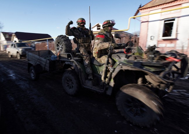 TOPSHOT - AFP PICTURES OF THE YEAR 2025 Russian soldiers ride a quad bike (ATV) in the village of Kazachya Loknya, which was previously held by Ukrainian troops and recently retaken by Russia's armed forces, in the Sudzha district of the Kursk region on March 18, 2025, amid the ongoing Russian-Ukrainian conflict. (Photo by TATYANA MAKEYEVA / AFP via Getty Images) / AFP PICTURES OF THE YEAR 2025