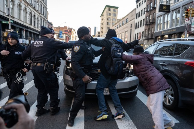 NEW YORK, NEW YORK - NOVEMBER 29: Immigration activists block ICE vans during a protest against a purported ICE raid on Canal Street on November 29, 2025 in New York City. Activists assembled outside of a garage used by ICE and later they tried to block ICE vehicles as they traveled from the garage down Canal Street to the Holland Tunnel to exit Manhattan. (Photo by Stephanie Keith/Getty Images)