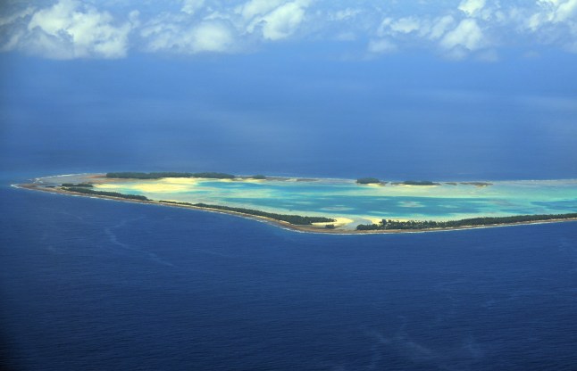 Funafuti Atoll, Tuvalu: aerial view of the south part of the atoll - lagoon surrounded by islets - Motuloa (left), Telele (center) and Funafal (right) islets, Avalau, Te Afuafou, Tengasu, Tutanga and Falaoigo island in the background - Tuvalu, a small island nation sinking in the Pacific Ocean, is one of the countries most vulnerable to climate change. With its highest point only about 4.5 meters (15 feet) above sea level, Tuvalu faces an existential threat from rising sea levels caused by global warming. The country is experiencing coastal erosion, saltwater intrusion into freshwater supplies, and more frequent and severe storms. These challenges are threatening the habitability of the islands, potentially forcing the population to relocate in the future. Tuvalu has become a vocal advocate for global climate action, urging larger nations to reduce greenhouse gas emissions and provide support for climate adaptation measures in vulnerable countries.