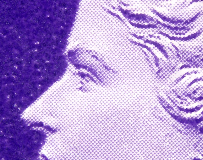 A micro close-up of a stamp of the late Queen Elizabeth II showing just her eye, nose and the top of her mouth to show where a tiny sculpture of yellow smiley face lies