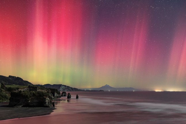 Northern Lights photographer of the year 2025 T&Cs MUST CREDIT PHOTOGRAPHER AND @capturetheatlas FOR SOCIAL MEDIA SHARING. ?Guardians of the Aurora? by Daniel Mickleson . A rare aurora event lit the west coast of New Zealand???s North Island in vivid curtains of pink and green. In the foreground, the rock formations known as the Three Sisters stand as guardians of the shoreline, while the sacred Taranaki Maunga rises in the distance. Within Te ao M??ori (the M??ori worldview), such natural features are not just landscapes but ancestral presences, carrying the role of guardianship. Beneath the aurora, earth, sky, and ancestry converge in a moment both fleeting and timeless. After capturing my first aurora during the May 2024 storm, I was hooked. Travelling several hours from my home to this special location, I hoped the forecasts would be correct. Even with a near???full moon, the powerful display shone across the sky. I could see the beams dancing overhead ??? a truly spectacular sight.