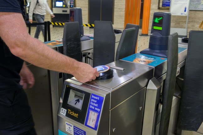 Man using card for getting through ticket barrier on the Tube