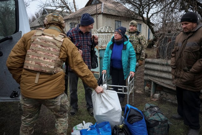 Members of the White Angels police evacuation unit assist residents during an evacuation from the frontline village of Kryvorizhzhia, amid Russia's attack on Ukraine, in Donetsk region, Ukraine December 9, 2025. REUTERS/Anatolii Stepanov