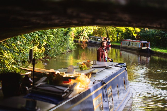 Story from Jam Press (Christmas On Narrowboat) Pictured: Josh on his 57ft narrowboat. 'We live on a 57ft narrowboat to save on rent and bills ? we have to move every TWO weeks, but it's worth it' A couple living on a 57ft narrowboat in a bid to save on rent and bills has revealed they have to move every two weeks ? but says it?s worth it. Tish and Josh made the decision to leave their traditional abode for a home on the water due to rising living costs in the UK. The pair, aged 36 and 35, now move locations every two weeks, which they say feels a bit like a ?holiday?. Even though the lifestyle looks ? and sounds ? appealing, it doesn?t come without its issues. Despite dealing with mounting rubbish, plus less time on their hands, they wouldn?t trade it for anything, including at Christmas. Especially as the holiday is set to be a scorcher for them, even though it?ll be just 14 degrees outside. ?Christmas will be hot,? the photographer, from Staffordshire, told?What's The Jam. ?Everyone assumes a boat will be cold in winter, but it?s [currently] 24 degrees inside. ?We don?t have the space for a tree in our boat, so we decorate our ceiling instead, and I have a friend who made us custom-made door bows to fit our tiny doors. ?It?s an incredibly cosy festive place to be.? The pair moved onto their boat in early 2024 after rising rent costs and the housing market left them rethinking things. She said: ?It was always part of our long-term plan to move onto a boat. ?We planned to retire to one, and then one day we asked ourselves why we were having the mindset that we needed to wait until our 60s to have the life we dreamed of. ?Our rent was continually going up, and the goal posts for the housing market kept moving. ?We?d been saving for years and never stopped to think about whether we even really wanted to buy a house or if it was just something we were taught was the next thing you do. ?When we really asked ourselves what we wanted out of a house, they were all things that a boat could provide us, with the added bonus of an adventure.? And often, it feels like they?re on a never-ending holiday. Josh said: ?Food shopping is a bit like being on holiday because every few weeks you?re in a new supermarket. ?Sometimes you forget where you left your home and auto-drive to the previous place you left it. ?Because of moving regularly, we?ve visited local areas we?d never thought to go into. ?We support local businesses more because now we know better places to buy things. ?But sometimes it?ll be six months until we?re back near those places, so we have to stock and plan around travelling.? Even though they?ve been?saving themselves a fortune each month, the costs do fluctuate per season, with winter the most costly. Tish said: ?Every boat is different to how the running costs are. ?Our fire is connected to our diesel tank, so we spend a lot more on diesel than others, but we spend zero on coal. ?For us personally, when we moved out of renting, our outgoings went down by roughly ?1,000 a month. ?But we have different costs to save for, like batteries, solar panels and blacking. ?Our costs are determined by the weather; summer is much cheaper because of sunlight. ?Winter is roughly ?200 a month more for us because of the increase in diesel for running the fire and charging our batteries for electricity. ?But when we lived in a house, we paid ?190 a month in gas and electric. ?Now we have about eight months of electricity powered by sunlight.? Their main costs include ?10 a month on gas, which lasts them four months at ?40 a bottle. Their license fee is ?122 per month, which they say would be the equivalent of council tax for a house. And as their boat measures a whopping 57ft, the prices aren?t set, as they vary based on size and if it?s docked in a marina. Outside of winter, they?re forking out around ?400 in fuel, and luckily, electric is free. Tish added: ?I?m asked a lot by people what it?s like to live on a boat, and it?s hard to put into words to someone because it?s a feeling more than anything, of peace. ?It?s not just a place to live but an entirely different mindset to life. ?We felt quite held down by our belongings, and it was very liberating getting rid of 90% of the things we own. ?What we hold value to now has changed; sunlight, water, nature and our loved ones are the most valuable things in our lives. ?Some things are harder ? it?s a more time-consuming way of life ? and I can?t pop my rubbish into my wheelie bin. ?If I?m lucky, I?ll find a bin a mile walk away. ?But, until then, it?s storing it until you pass a bin. ?If a fuel boat isn?t passing where I am, then we have to fetch fuel. ?We don?t have room for a washing machine, so we have to leave our home to wash clothing. ?And it takes five hours to sail a 12-minute car journey.? ?It?s all things that take up more time ? but, for me, the benefits far outweigh any negatives. ?I?ve been a long-time sufferer of mental health, and the changes were day and night, living on water just agrees with me. ?I have seen things some people will never see with their own eyes, and the closeness to nature gives you a totally new respect for it. ?I?ve rescued a squirrel out of the canal, I?ve had ducklings asleep next to my front door, we saw a mole digging next to our window once, ducks and swans regularly knock on our boat asking for food, and I once came home to a horse escaped on the towpath ?I know that sounds very appealing, and in a world where everything costs too much, it looks like a wonderful solution to a cost-of-living crisis. ?But batteries don?t last forever, blacking is done every few years, and there are lots of other costs to factor into. ?So if it?s something you?d be considering, money is the wrong reason to do it; it's a way of life, and that?s the main reason to do it.? ENDS EDITOR'S NOTE: Video Usage Licence: (EXCLUSIVE) We have obtained an exclusive licence from the copyright holder. A copy of the licence is available on request. Video Restrictions: None.