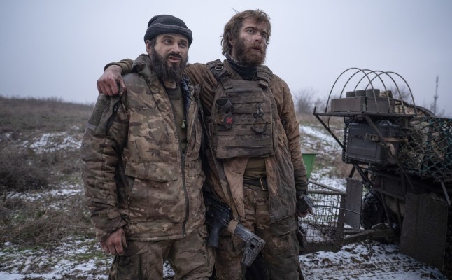 In this photo, taken Tuesday, Dec. 16, 2025 and provided by Ukraine's 93rd Kholodnyi Yar Separate Mechanized Brigade press service, Ukrainian soldiers Denis "Bars" and Dmytro "K2" hug each other after their return from a position where they fought for 130 days near Kostyantynivka, Donetsk region, Ukraine. (Iryna Rybakova/Ukraine's 93rd Mechanized Brigade via AP)