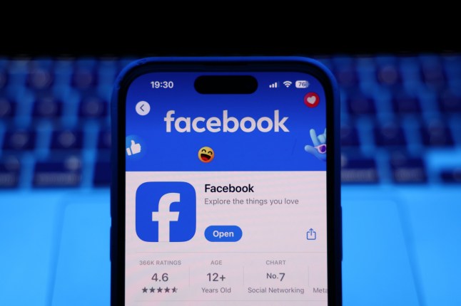 A laptop keyboard and Facebook on App Store displayed on a phone screen are seen in this illustration photo taken in Krakow, Poland on March 17, 2025. (Photo by Jakub Porzycki/NurPhoto via Getty Images)