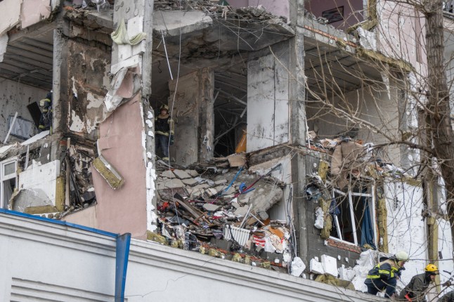 Ukrainian rescuers look through rubble inside a damaged residential building following Russian drones and missiles attack, in Kyiv, on December 27, 2025, amid the Russian invasion in Ukraine. Several powerful explosions rocked Kyiv on December 27, 2025 as authorities warned that the Ukrainian capital was under threat of missile attack. (Photo by Serhii Okunev / AFP via Getty Images)