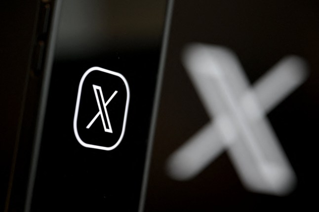 This illustration photograph shows the logo of social network X (formerly Twitter) displayed on a smartphone in Brussels on September 27, 2024. (Photo by Nicolas TUCAT / AFP) (Photo by NICOLAS TUCAT/AFP via Getty Images)