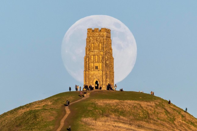 Alamy Live News. 3DDN7HJ Glastonbury, Somerset, UK. 2nd January 2026. UK Weather. The almost full Wolf Moon moon rises up in to the clear evening afternoon from behind St Michael?s Tower on Glastonbury Tor at Glastonbury in Somerset as a large crowd watches. This months full moon is on 3rd January will be a supermoon. Picture Credit: Graham Hunt/Alamy Live News This is an Alamy Live News image and may not be part of your current Alamy deal . If you are unsure, please contact our sales team to check.